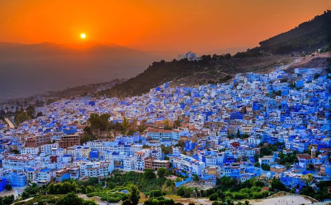 Panorama nocturne de Chefchaouen avec ses maisons bleues illuminées, reflétant l’atmosphère unique et la mémoire vivante de la ville