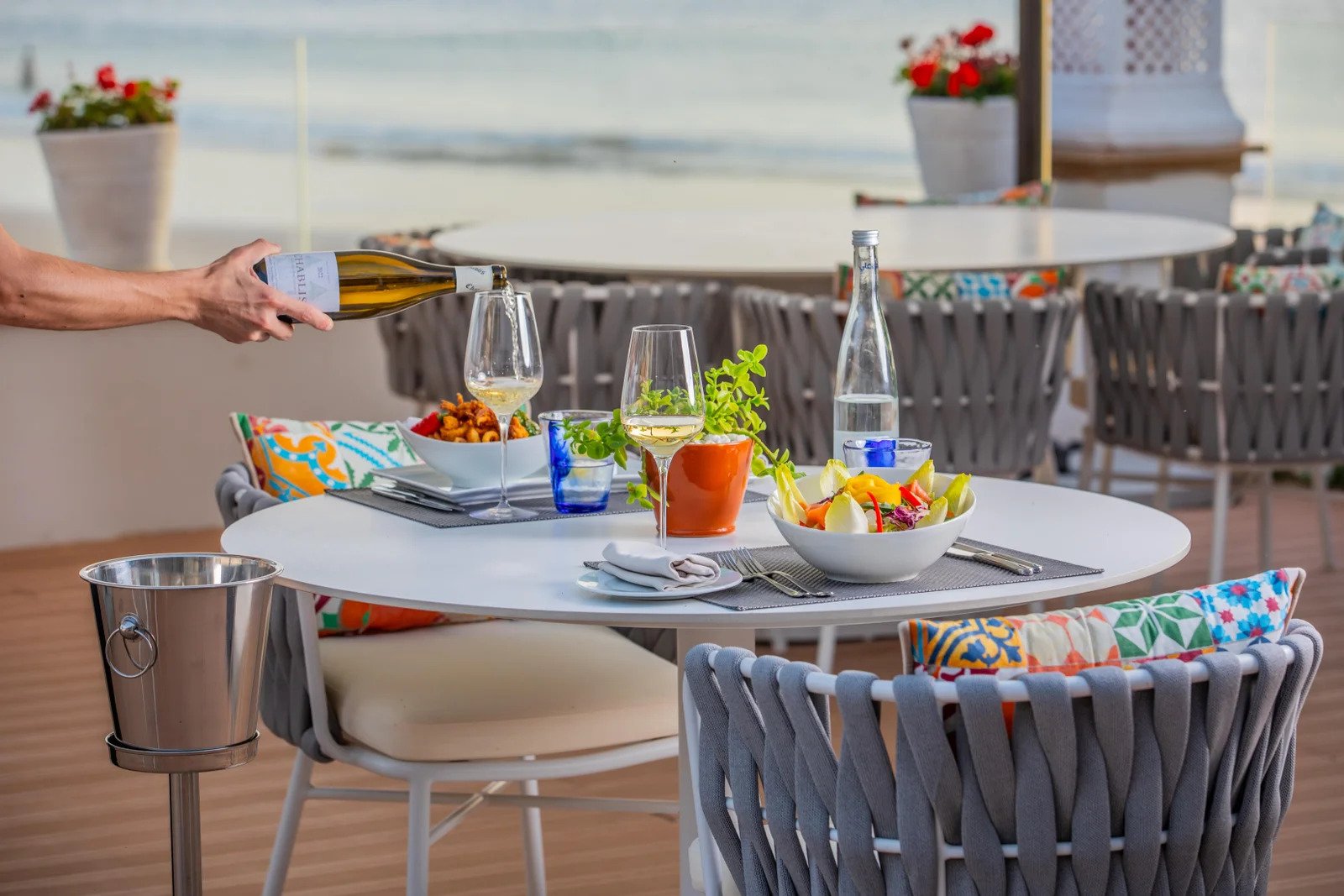 Terrasse en plein air du restaurant Beach Club suspendue au dessus de l eau face a la plage