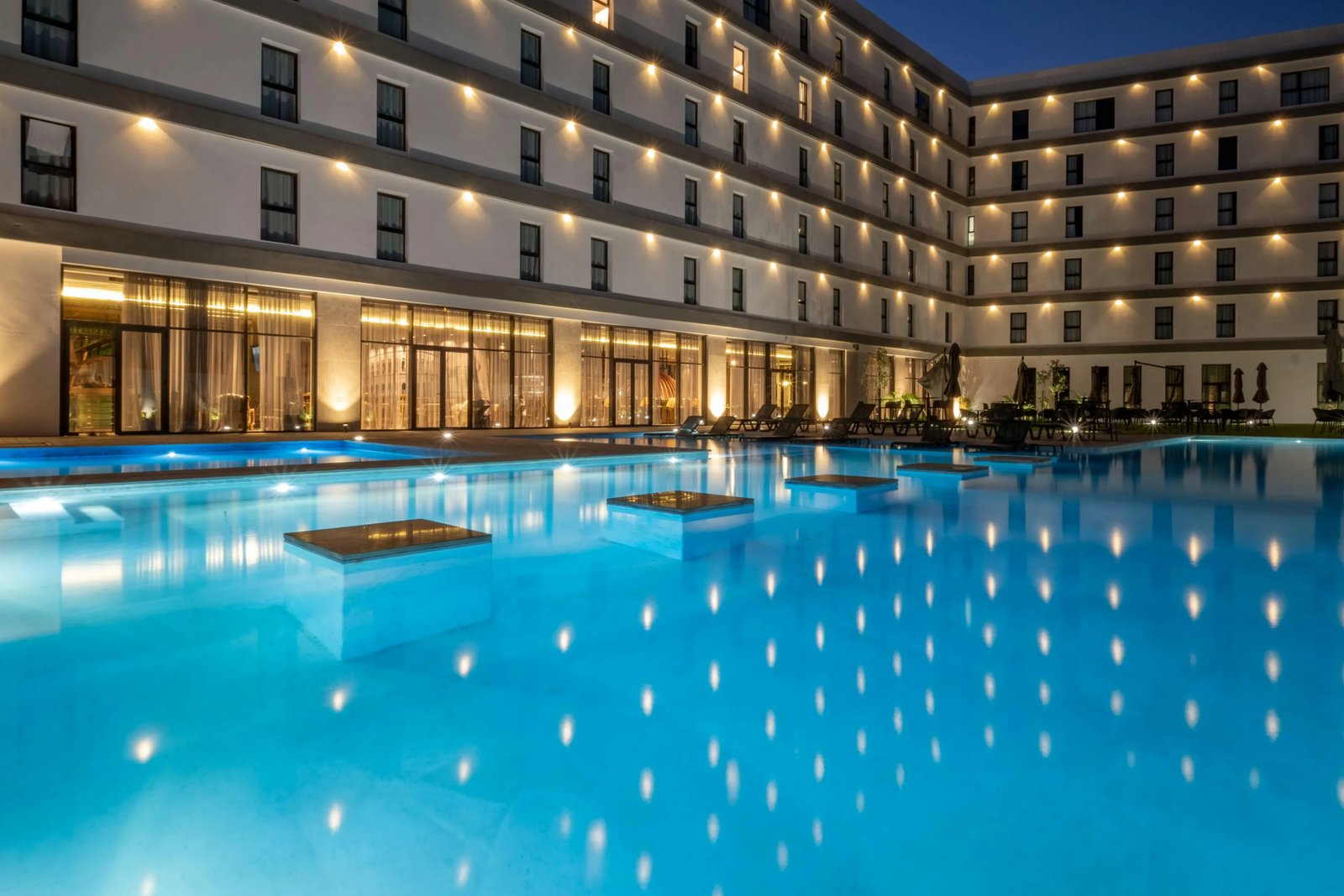 La piscine extérieure pendant le soir aux reflets nacrés à l'hôtel Occidental Tanger.