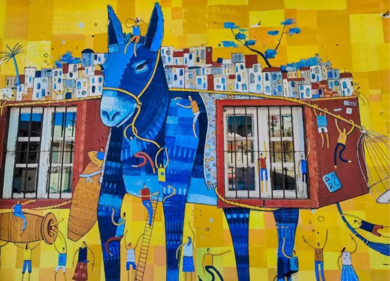 Grande fresque murale colorée représentant un âne bleu portant la médina, visible au Donkey Museum of Tangier