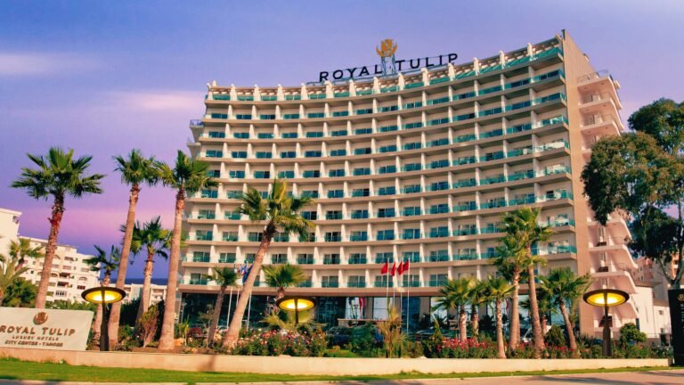 Série Vacances en septembre – Le Royal Tulip : Notre sixième escale sous le signe du raffinement Façade de l'hôtel Royal Tulip City Center Tanger sous un ciel de crépuscule en arrière-saison.