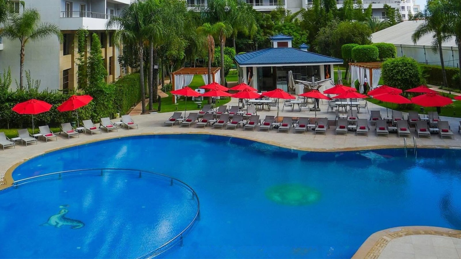 Grande piscine extérieure de l'hôtel Royal Tulip Tanger idéale pour admirer le crépuscule en septembre.