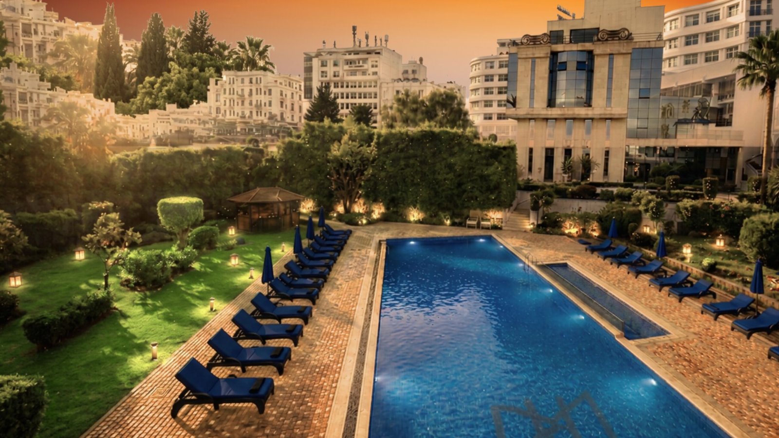 Piscine extérieur de l'Hôtel El Minzah sous un coucher du soleil orangé pendant des vacances en septembre à Tanger.