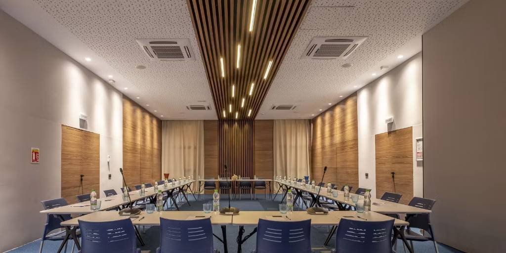 Espaces événementiels vus de face avec une structure de table symétrique et un plafond boisé.