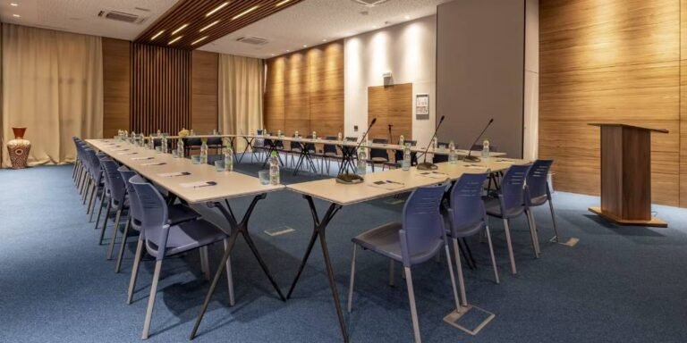 Espaces événementiels de l'établissement avec tables en U et pupitre de conférence.