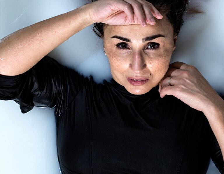 Nadia Lamarti en gros plan allongée, la main sur le front, pour l'affiche de son spectacle.