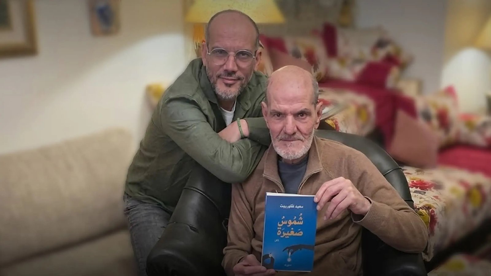 Le journaliste et poète Saïd Koubrit aux côtés de son père, qui tient entre ses mains l'un des recueils de poésie de son fils.