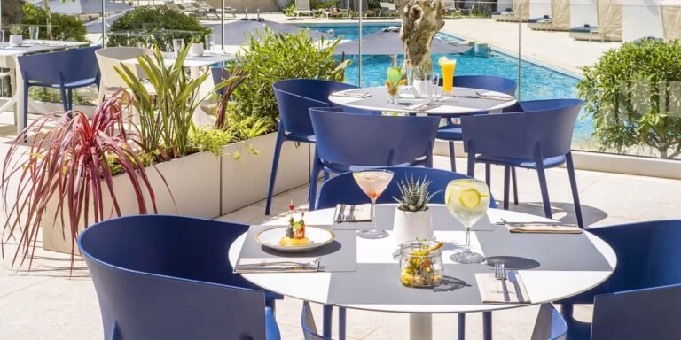 Terrasse moderne avec tables dressées et cocktails au bord de la piscine du Barceló Tanger.