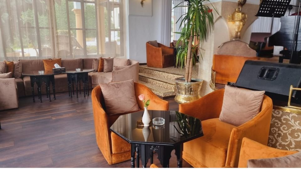 Salon feutré avec fauteuils et piano au Caids Bar de l hôtel El Minzah