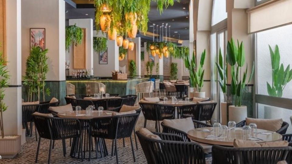 Tables de restaurant sous des plantes suspendues, un espace des restaurants de l'hôtel