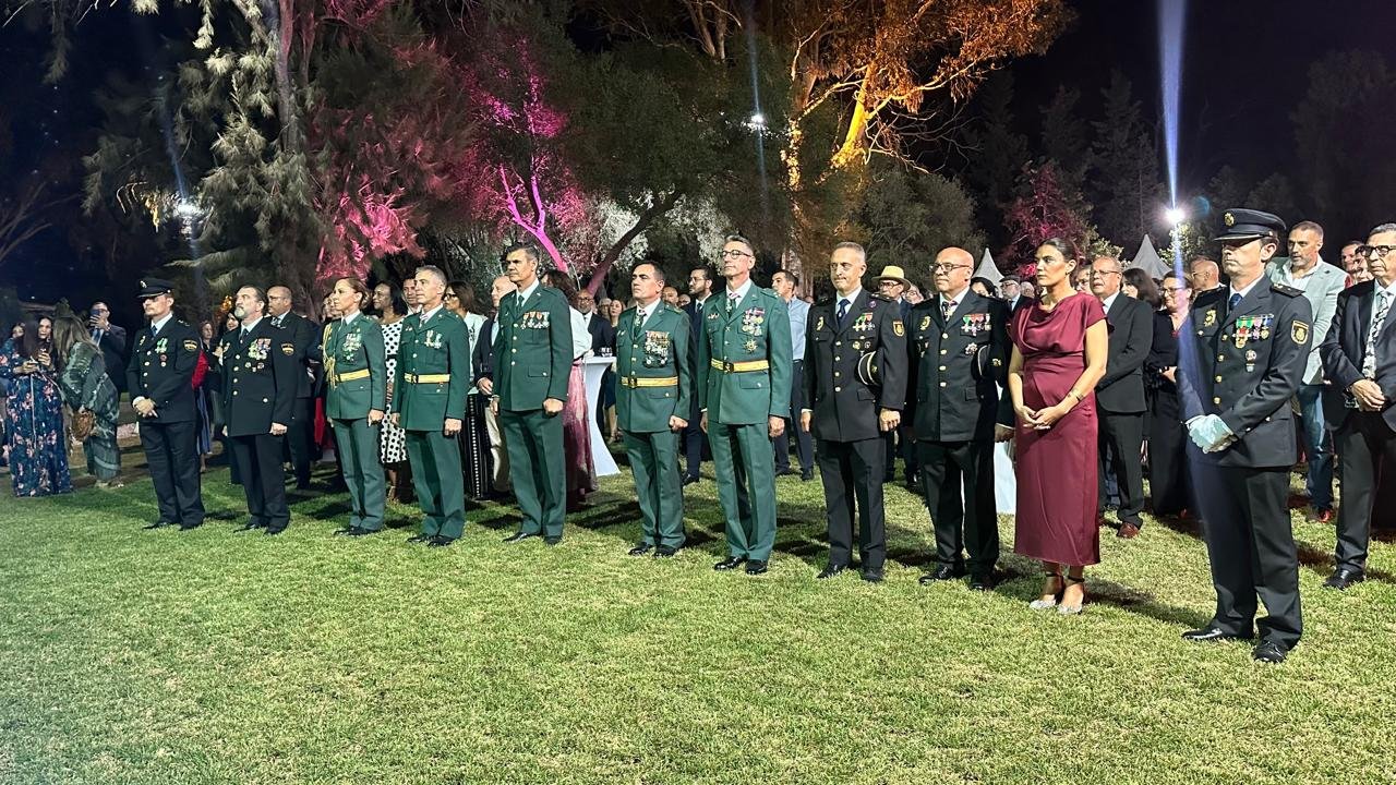 Alignement d'officiels et de militaires espagnols en uniforme de cérémonie sur la pelouse du Consulat d'Espagne à Tanger pendant les hymnes nationaux.