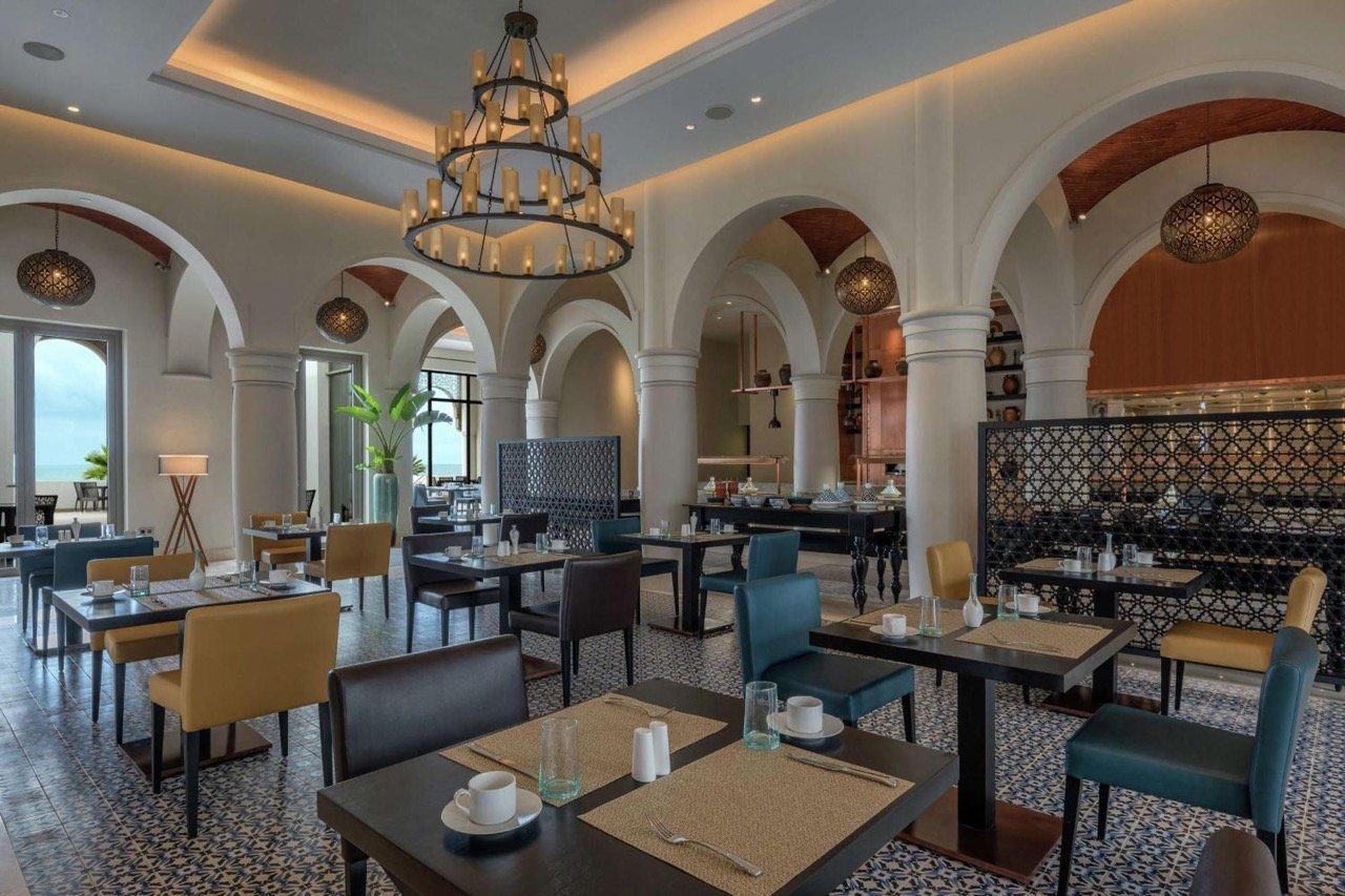 Tables dressées dans la grande salle lumineuse du restaurant L'Argan, l'un des restaurants du Hilton Al Houara à Tanger.