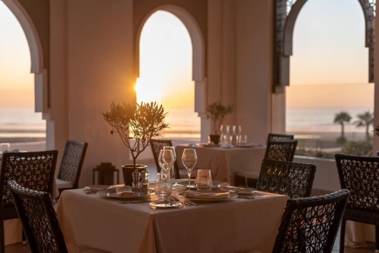 Série gastronomique : les hôtels du Détroit – Épisode 9 : Le Hilton Tangier Al Houara Resort & Spa Table dressée au coucher du soleil avec vue sur l'océan et la plage aux restaurants du Hilton Al Houara à Tanger