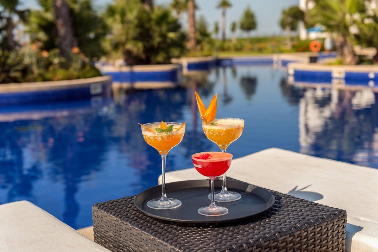 Plateau de cocktails tropicaux posé au bord de la piscine extérieure au Tucano Pool Bar