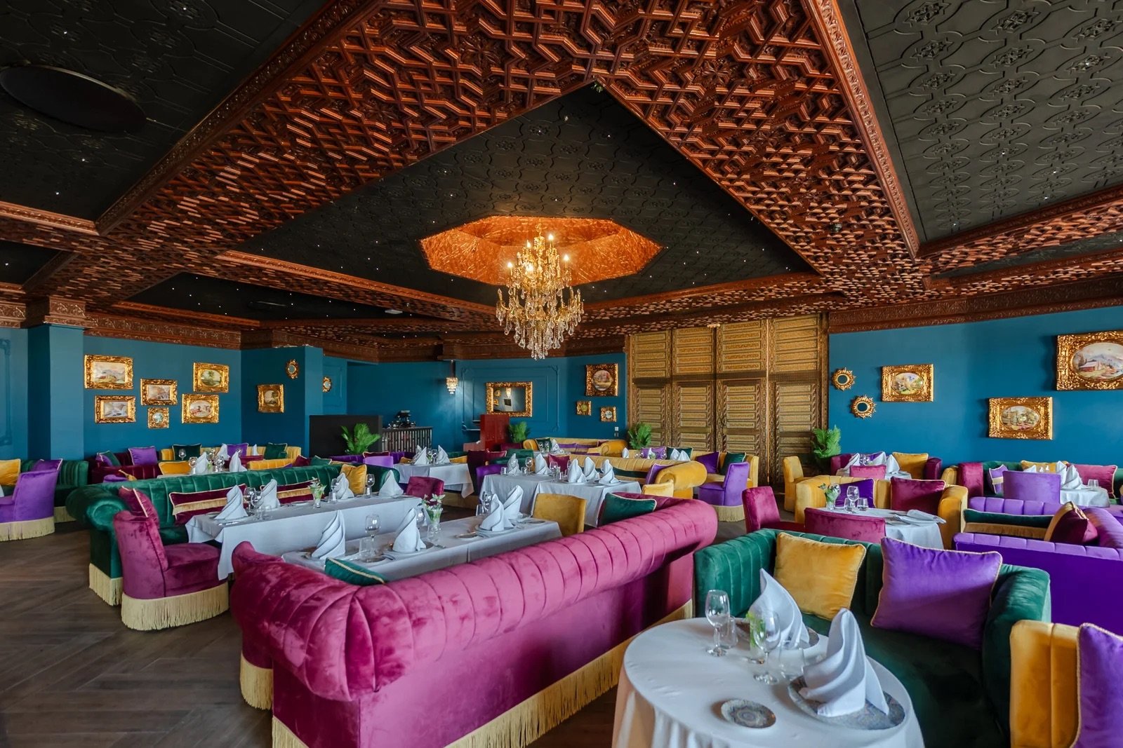Salon en velours sous plafond sculpté, une table des restaurants du Kenzi Solazur Hotel.
